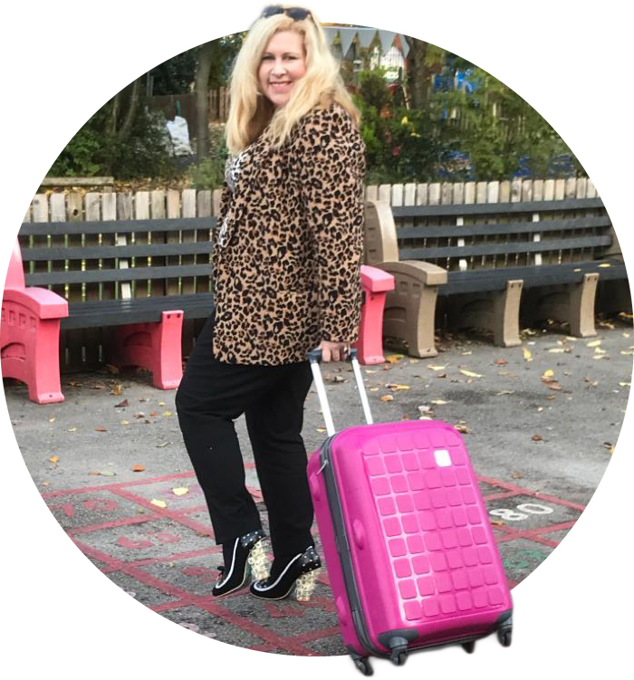 Helen, pulling a cart of learning resources in a playground, wearing shoes with dice in the heels.